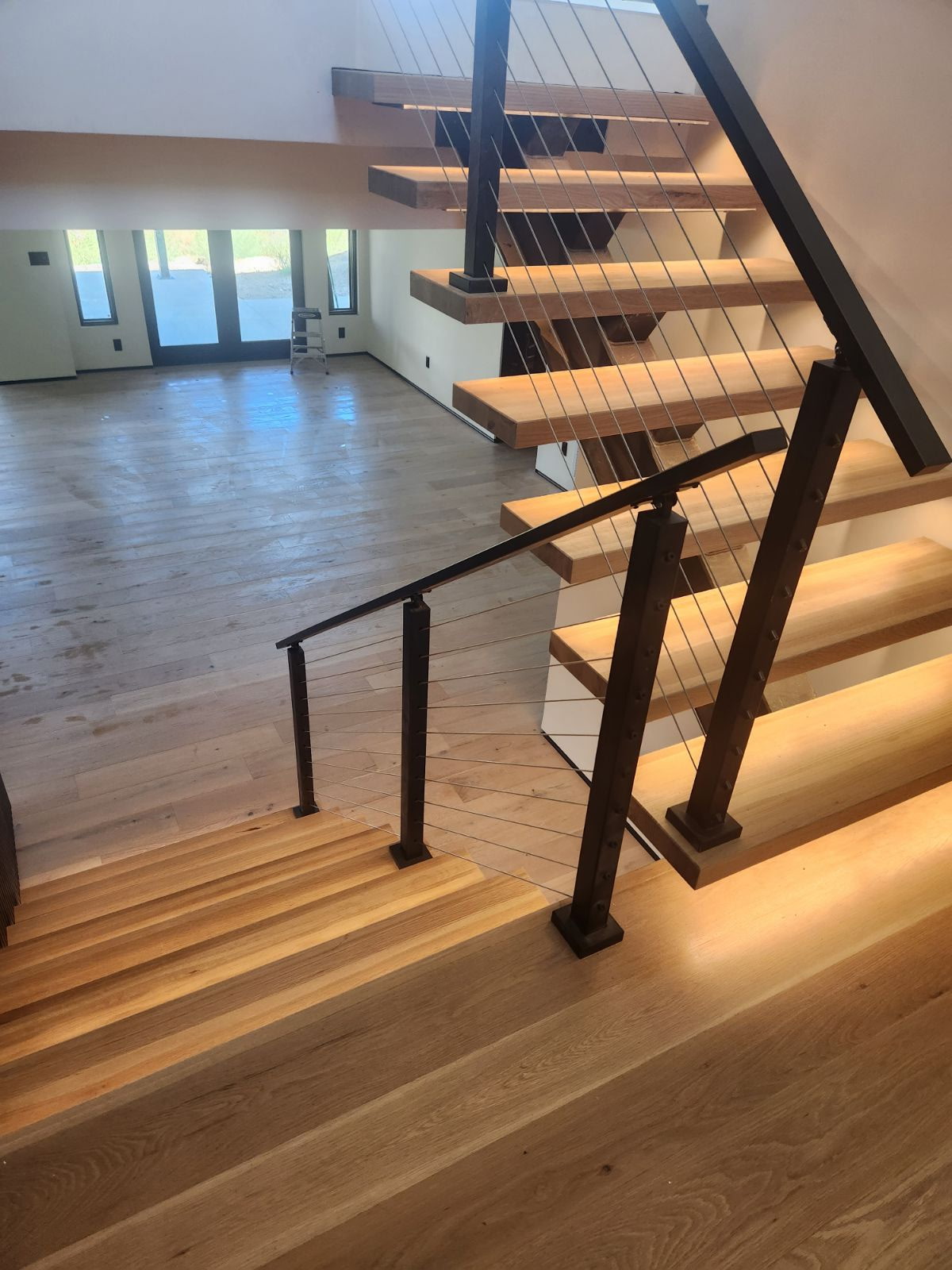 Floating white-oak staircase with steel and cable railing