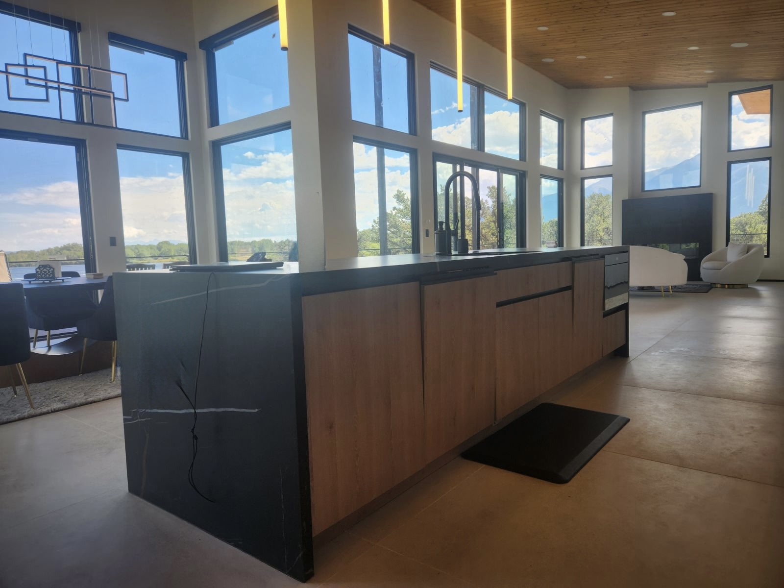 Custom kitchen island with waterfall quartz and wall of windows